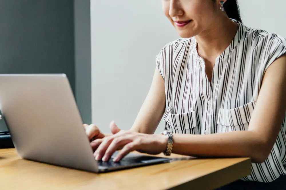 Mature woman typing on laptop
