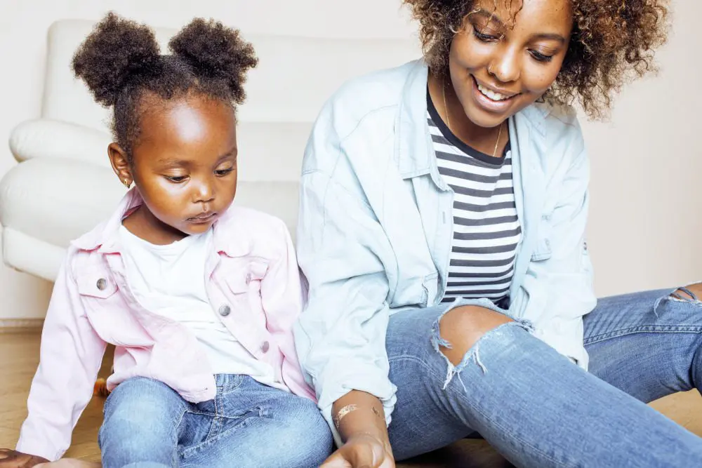 Mother and daughter playing together while sitting on the floor.