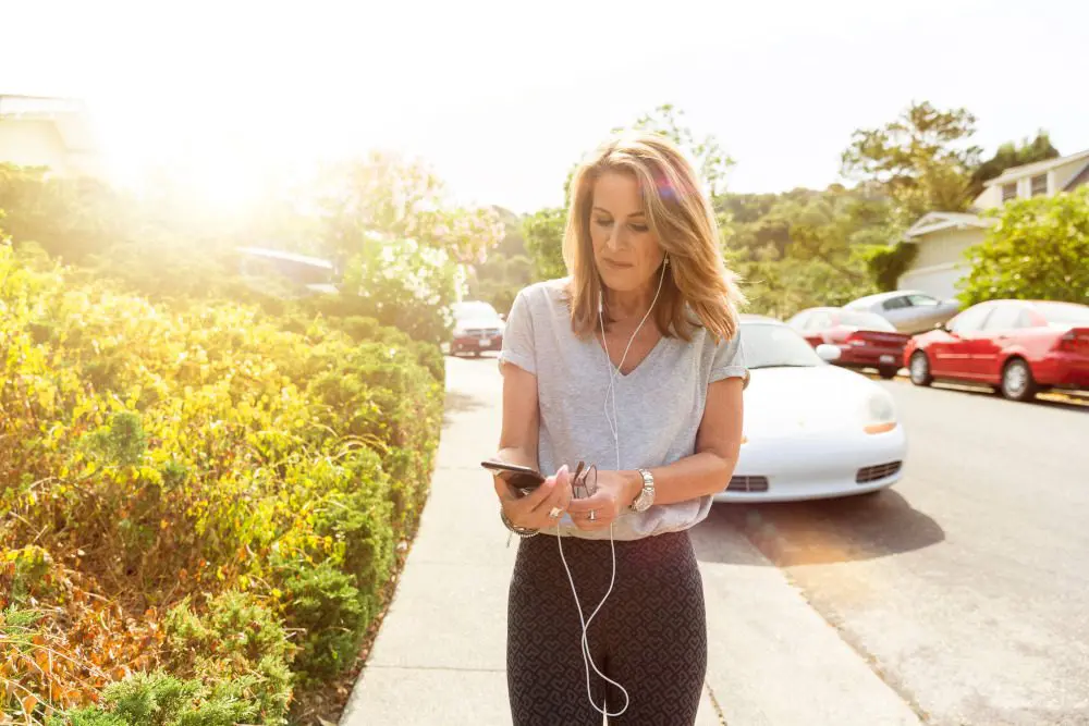 Woman walking while looking at her phone.